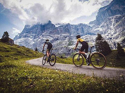 two road bike athletes climbing a pass road